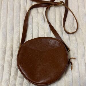 Portland Leather Goods Brown Embossed genuine leather round Crossbody Bag.